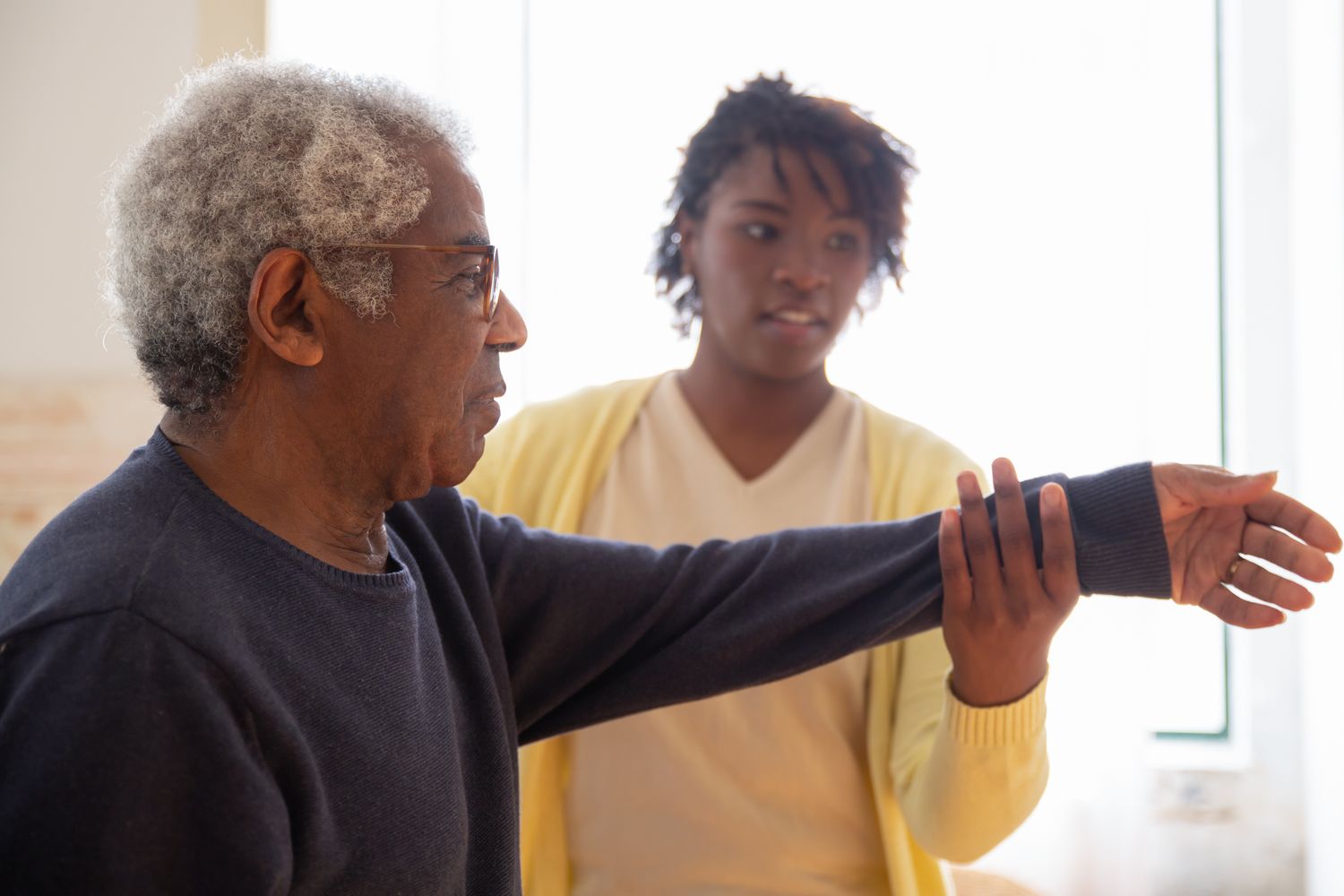 A massage therapist working with an older veteran during a session